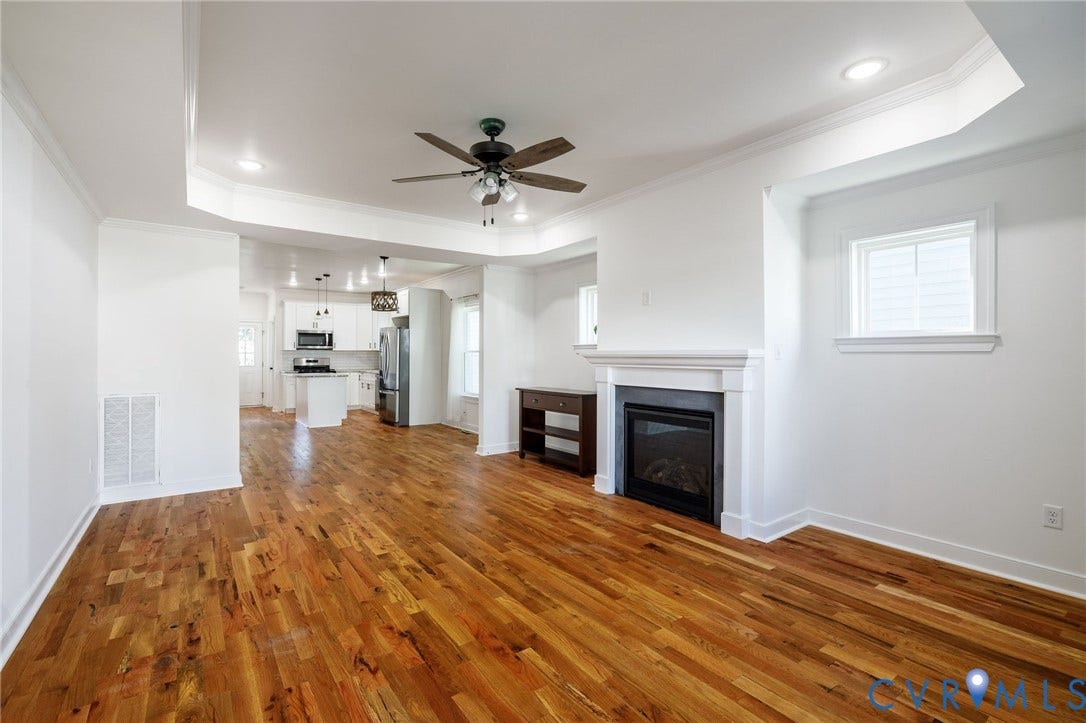2902 Lawson Street, Richmond, VA 23224 Open concept interior featuring wood-finish flooring, recessed lighting, a tray ceiling, and a fireplace with a white mantel