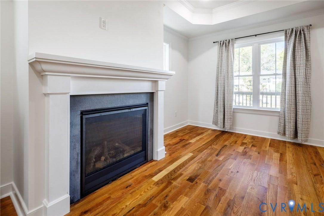2902 Lawson Street, Richmond, VA 23224 Gas fireplace with a stone-surround and classic white mantel, wood-finish flooring, and tray ceiling