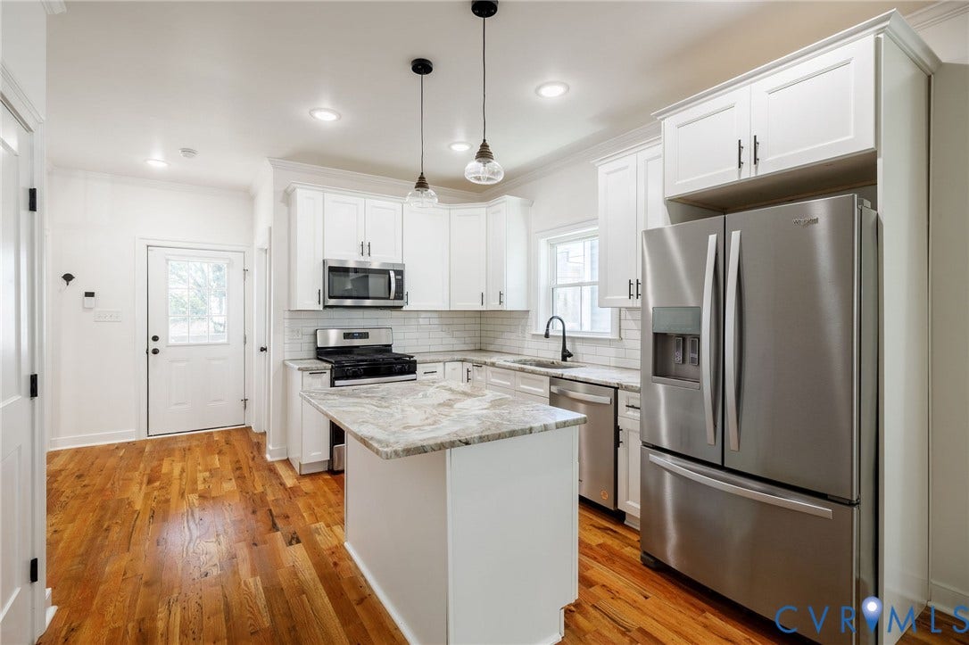 2902 Lawson Street, Richmond, VA 23224 Kitchen featuring white shaker-style cabinetry, stone-finish countertops, stainless steel appliances, a center island, and wood-finish flooring