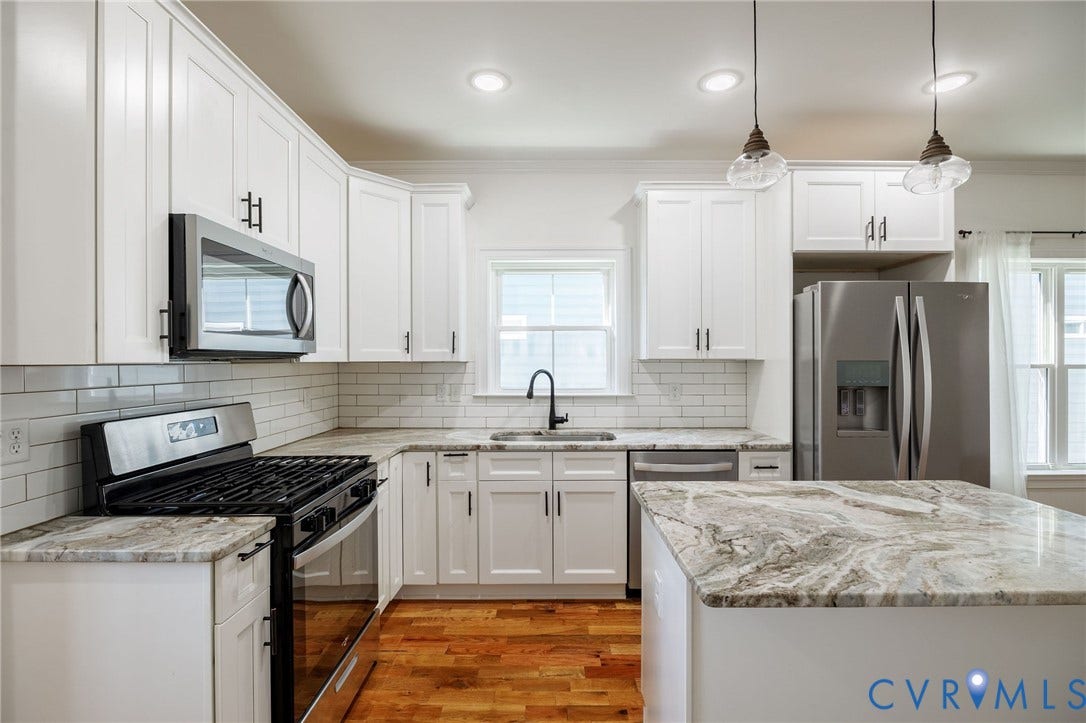2902 Lawson Street, Richmond, VA 23224 Kitchen featuring white shaker-style cabinetry, natural stone countertops, a subway tile backsplash, stainless steel appliances, and wood-finish flooring