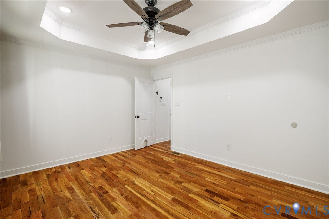 2902 Lawson Street, Richmond, VA 23224 Tray ceiling featuring recessed lighting and a central multi-blade ceiling fan with integrated lighting, complemented by wood-finish flooring and solid-core interior doors