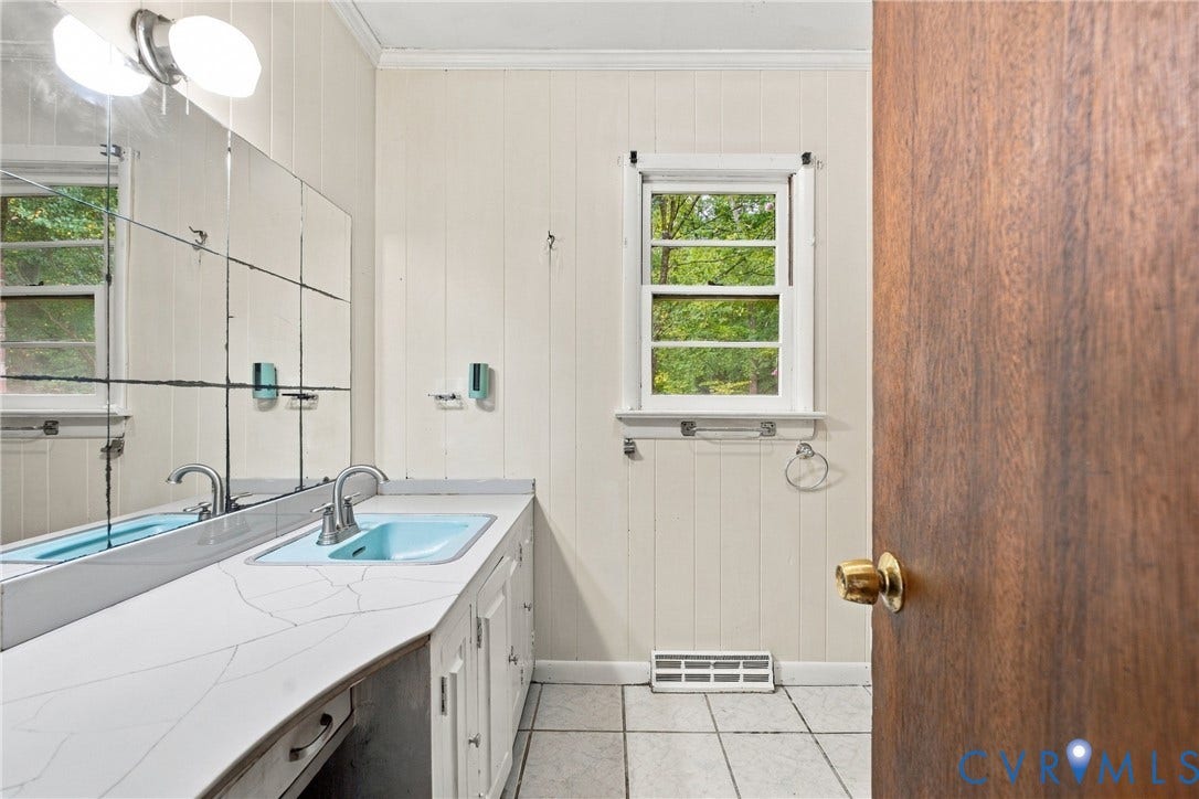 8150 Bradbury Road, Henrico, VA 23231 Vanity with an integrated basin, wall-mounted mirror, and overhead lighting fixture
