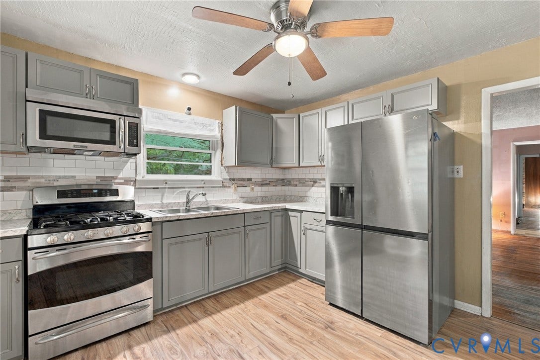 8150 Bradbury Road, Henrico, VA 23231 Kitchen featuring grey cabinetry, stainless steel appliances, wood-finish flooring, a ceiling fan, and a tile backsplash