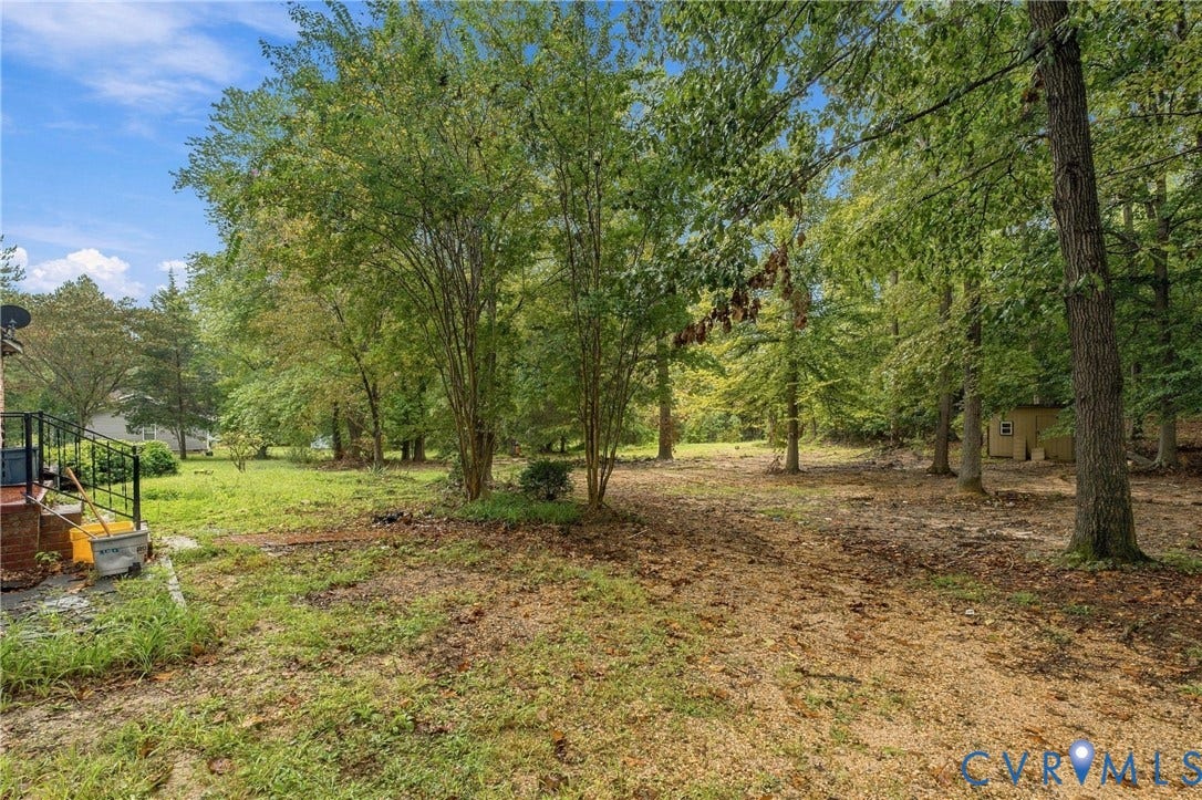 8150 Bradbury Road, Henrico, VA 23231 Expansive wooded lot featuring mature trees and a detached shed