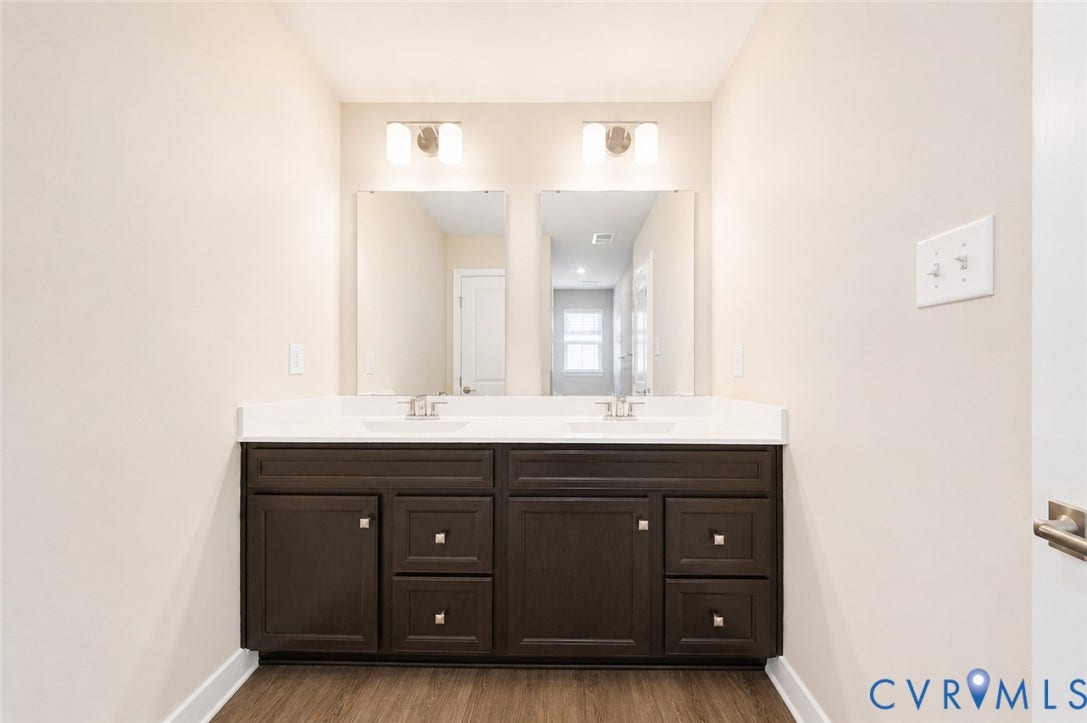 10607 Pink Lilly Lane, Chester, VA 23831 Dual vanity with dark wood-finish cabinetry, white countertop, and integrated sinks