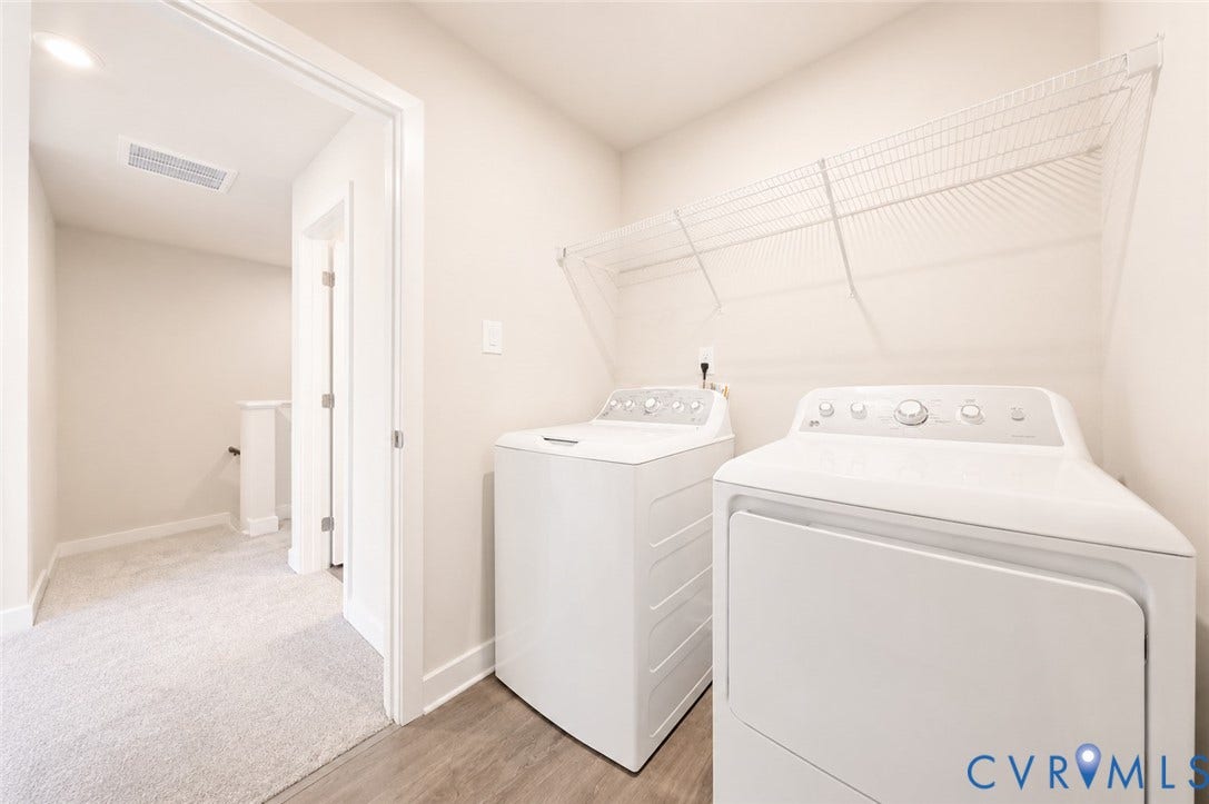 10607 Pink Lilly Lane, Chester, VA 23831 Laundry area featuring wood-finish flooring, overhead wire shelving, and neutral wall paint