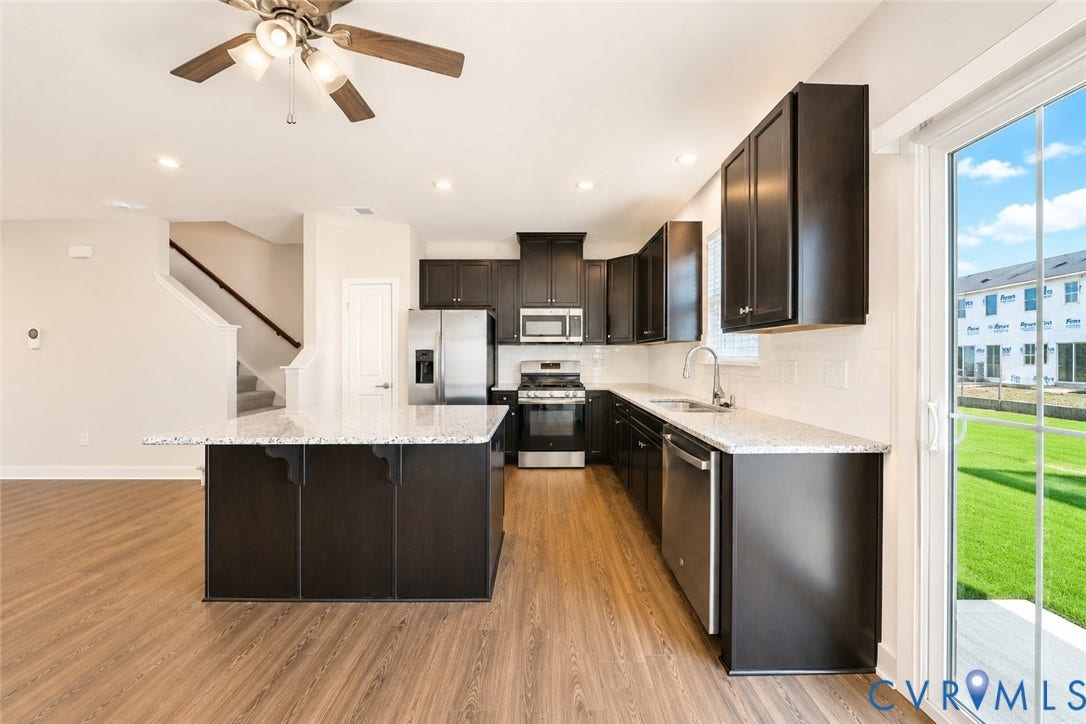 10607 Pink Lilly Lane, Chester, VA 23831 Kitchen featuring dark wood cabinetry, light-toned countertops, stainless steel appliances, and wood-finish flooring