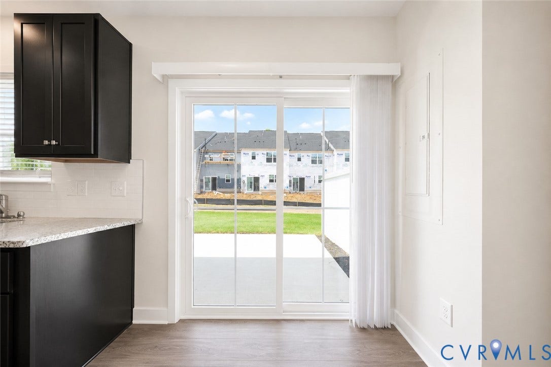 10607 Pink Lilly Lane, Chester, VA 23831 Sliding glass door, wood-finish flooring, dark cabinetry, light-toned countertops, white subway tile backsplash