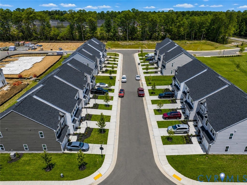 10607 Pink Lilly Lane, Chester, VA 23831 New construction townhomes featuring dark gray shingle roofs, light gray siding, and attached garages