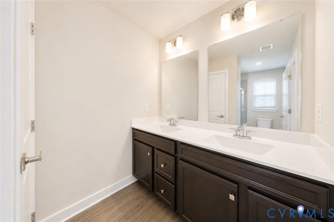 10607 Pink Lilly Lane, Chester, VA 23831 Double vanity with dark wood-finish cabinetry, white countertop, and integrated sinks