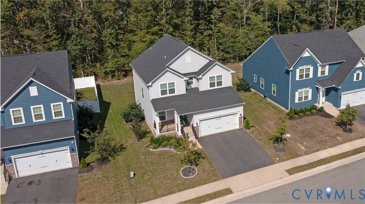 1943 Enon Station Drive, Chester, VA 23836 Two-story residence with a light gray siding exterior, featuring a covered front porch, an attached garage, and a paved driveway