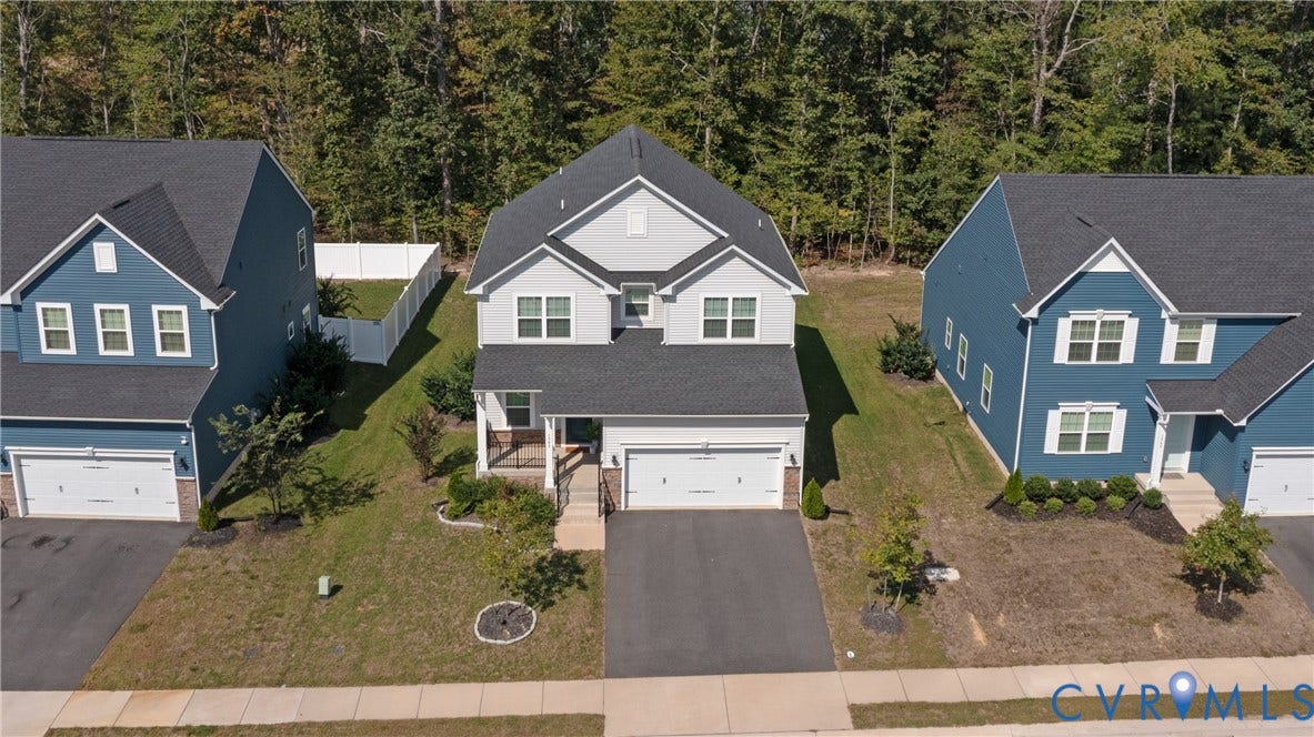 1943 Enon Station Drive, Chester, VA 23836 Two-story residence with a gray siding exterior, an attached garage, a covered front porch, and a paved driveway