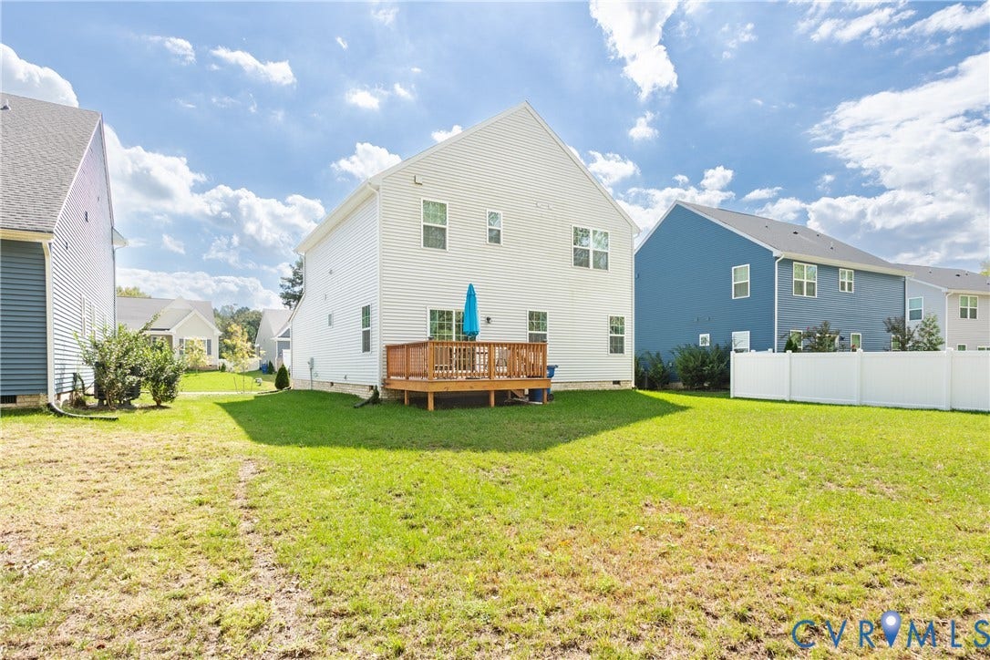 1943 Enon Station Drive, Chester, VA 23836 Rear exterior featuring light-colored siding, a wooden deck, and a spacious green lawn