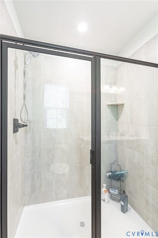 1943 Enon Station Drive, Chester, VA 23836 Glass-enclosed shower with matte black framing, tiled walls, and a built-in corner shelf