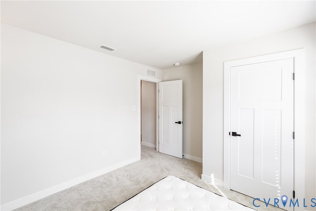 1943 Enon Station Drive, Chester, VA 23836 Light-toned wall paint, plush carpet flooring, white trim, and white paneled doors with black hardware