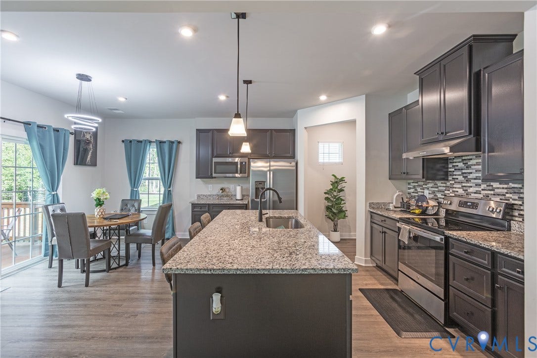 1943 Enon Station Drive, Chester, VA 23836 Kitchen featuring dark cabinetry, stainless steel appliances, granite countertops, and a mosaic tile backsplash