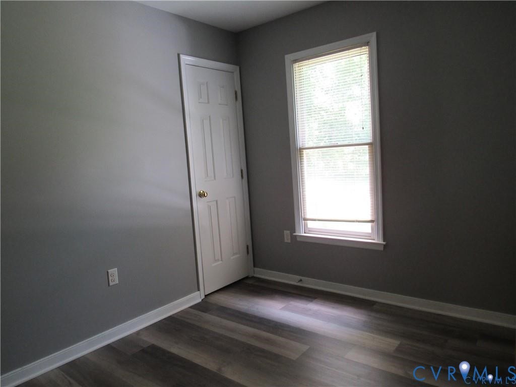 8506 Lyndale Drive, Chesterfield, VA 23235 Wood-finish flooring, neutral gray walls, bright window with blinds, white trim, and a paneled interior door