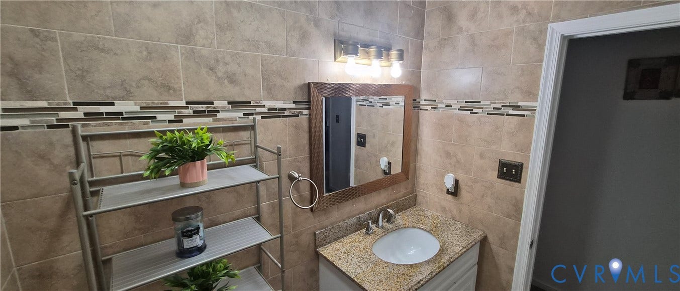 Vanity with a granite countertop, undermount sink, and brushed nickel faucet