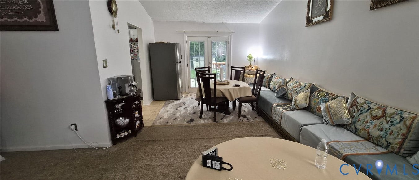 Dining area with exterior access via French doors, featuring tile flooring