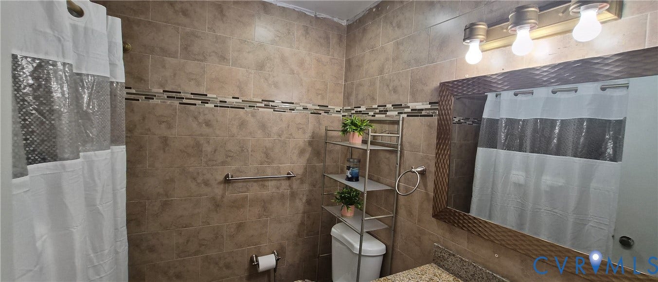 Full-height tiled walls featuring a decorative tile inlay