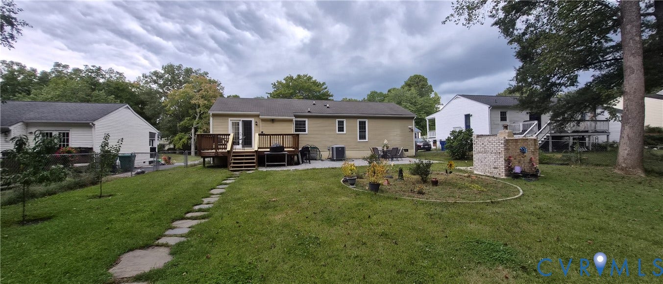 Expansive backyard featuring a stone paver pathway, manicured lawn, and a raised planting bed