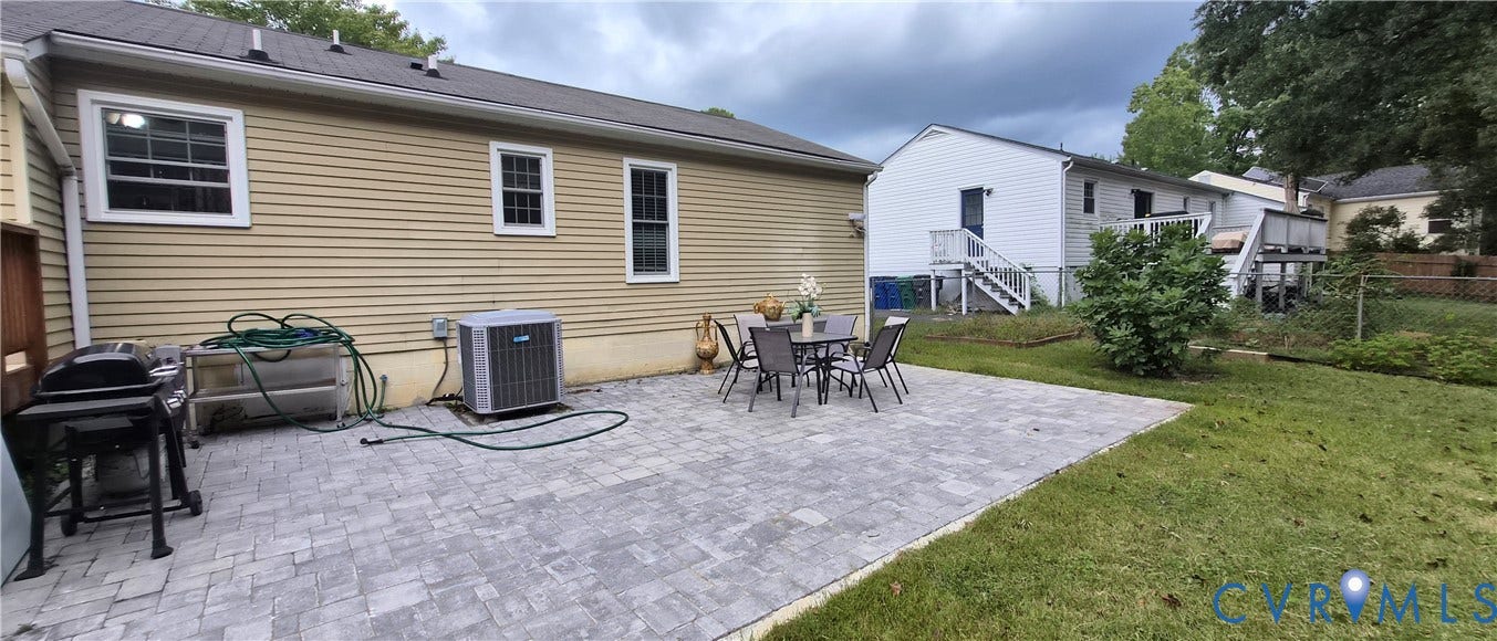Paved patio area, horizontal siding exterior, and a manicured lawn