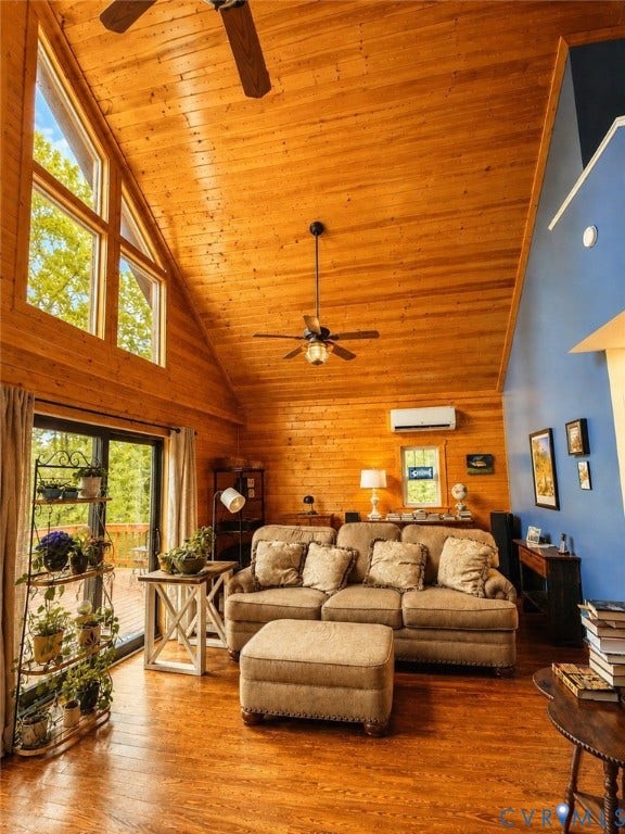 Vaulted wood-paneled ceiling, wood-finish flooring, accent wall, and a sliding glass door to exterior decking