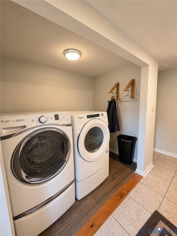 Dedicated laundry area featuring a flush mount ceiling light, wood-finish flooring, and a tiled floor transition