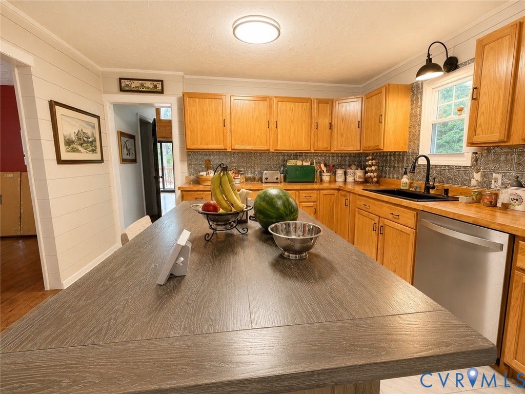 Kitchen featuring wood-finish cabinetry, stainless steel dishwasher, black sink with matte black faucet, and patterned backsplash