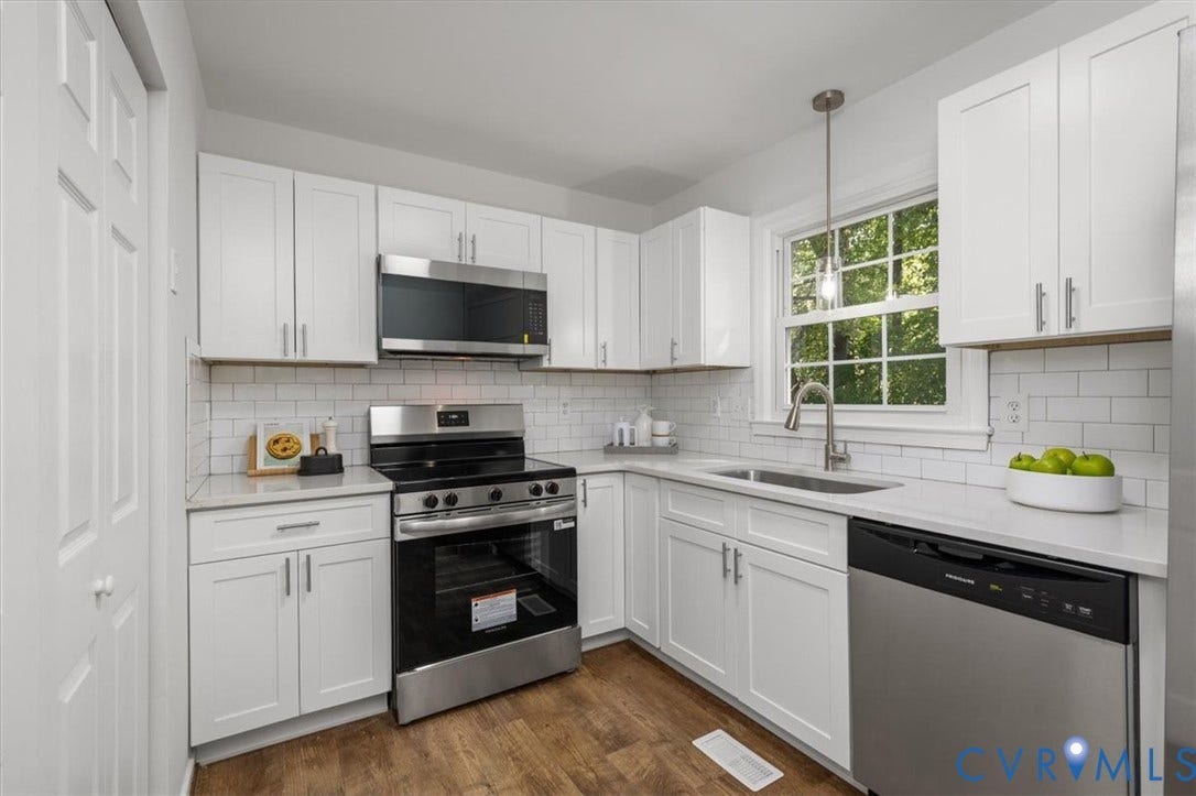 3031 Speeks Drive, Midlothian, VA 23112 White shaker cabinetry, stainless steel appliances, white subway tile backsplash, light-toned countertops, and wood-finish flooring