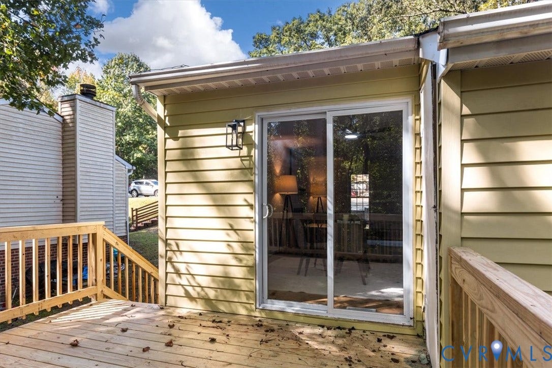 3031 Speeks Drive, Midlothian, VA 23112 Spacious wood deck with wood railings, sliding glass door access, and an exterior wall lantern