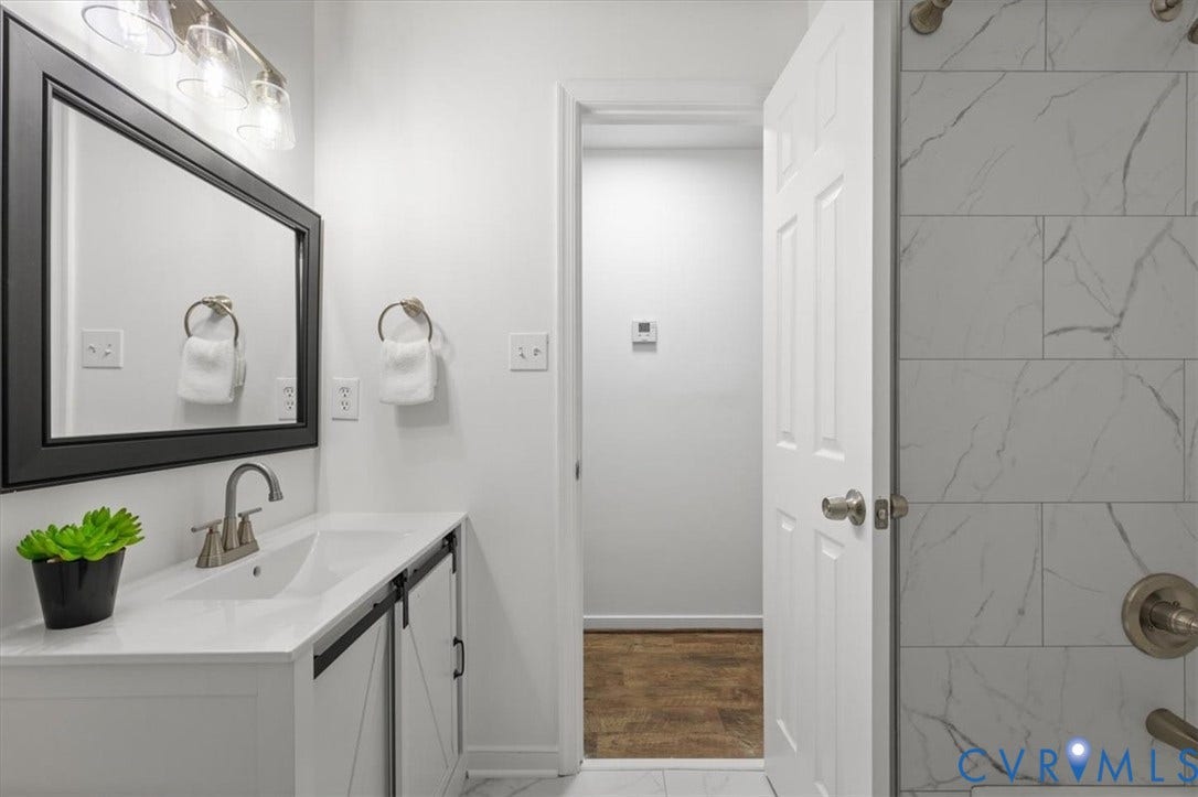 3031 Speeks Drive, Midlothian, VA 23112 Vanity with integrated sink, black-framed mirror, brushed nickel faucet, and barn door style cabinetry