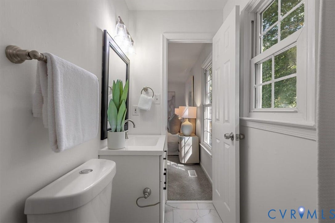 3031 Speeks Drive, Midlothian, VA 23112 White vanity with an integrated sink and brushed nickel faucet, a framed mirror, and an overhead vanity light