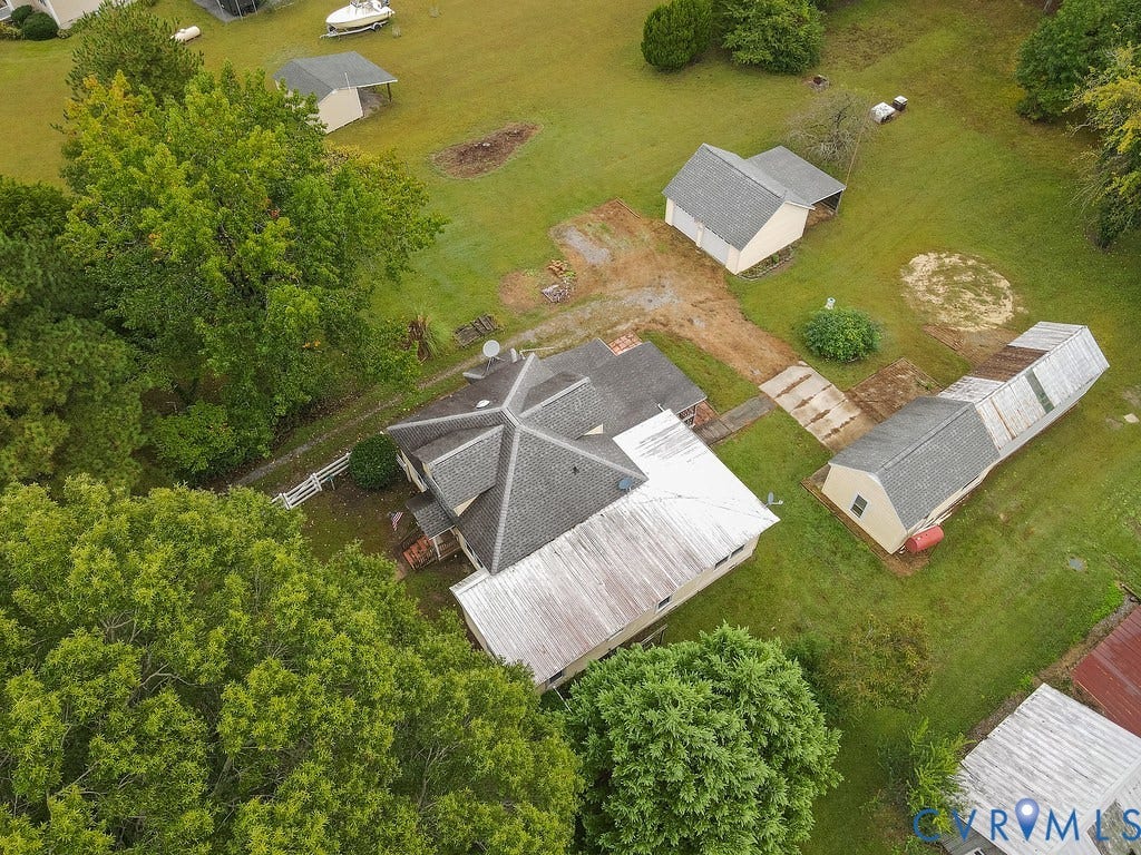 Expansive green space with mature trees, multiple outbuildings, and a main residence featuring a multi-gabled roof