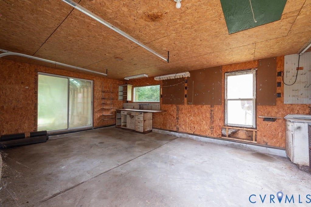 Sliding glass door, concrete flooring, built-in shelving, built-in cabinetry, dual windows