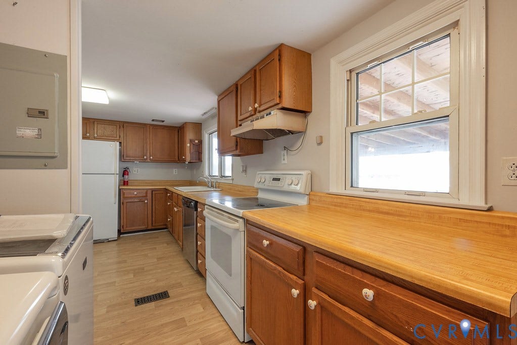 Kitchen featuring wood-finish flooring, wood cabinetry, and a double-hung window