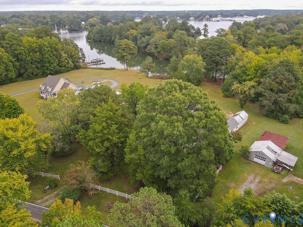 Scenic riverside estate set on expansive grounds with mature landscaping and tree-lined perimeter