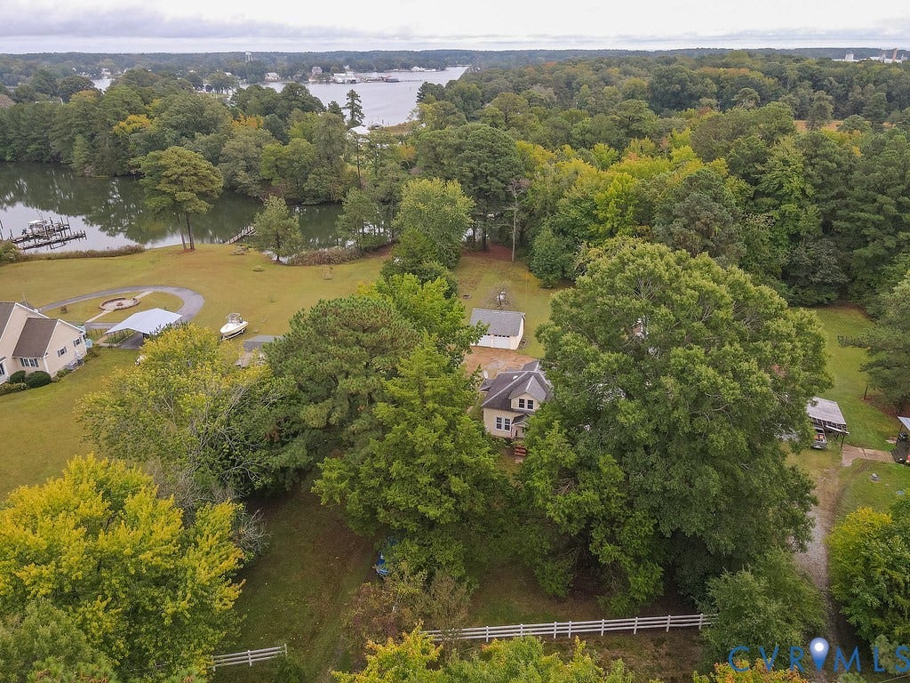 Waterfront property with private boat dock, surrounded by mature trees and lush landscaping