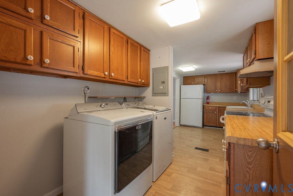 Wood-finish flooring, wood cabinetry with white knobs, white appliances, and a wood countertop