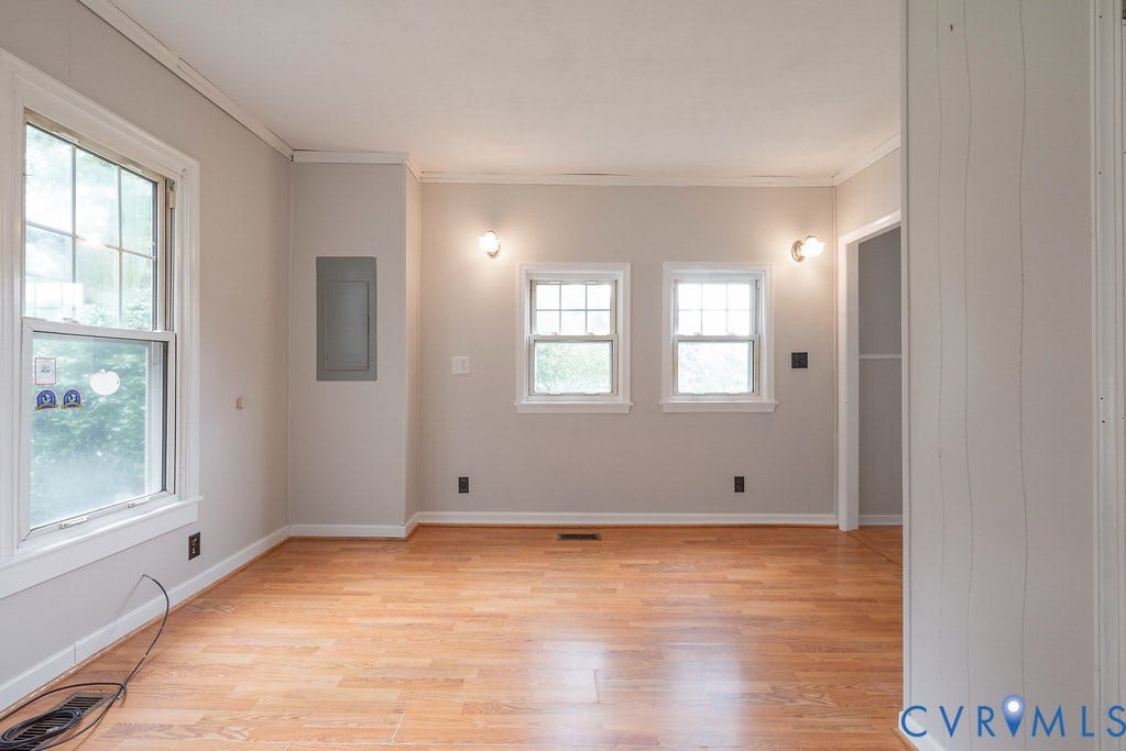 Light-toned wood-finish flooring, two large windows, three smaller windows, and built-in wall sconces