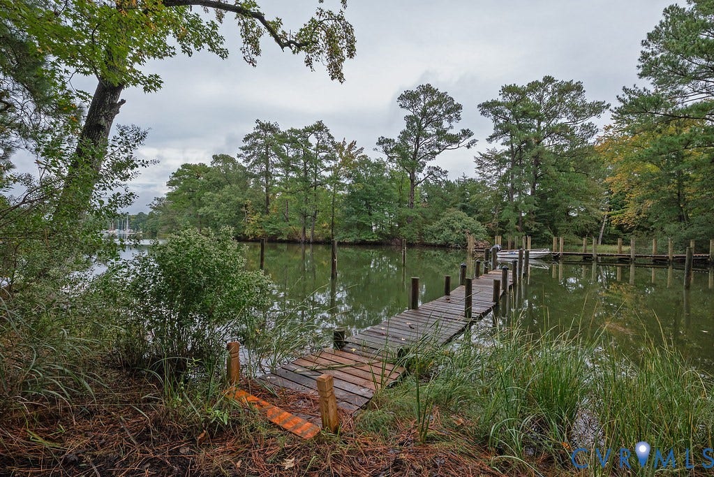 Private waterfront access with an extended wooden dock and multiple mooring posts
