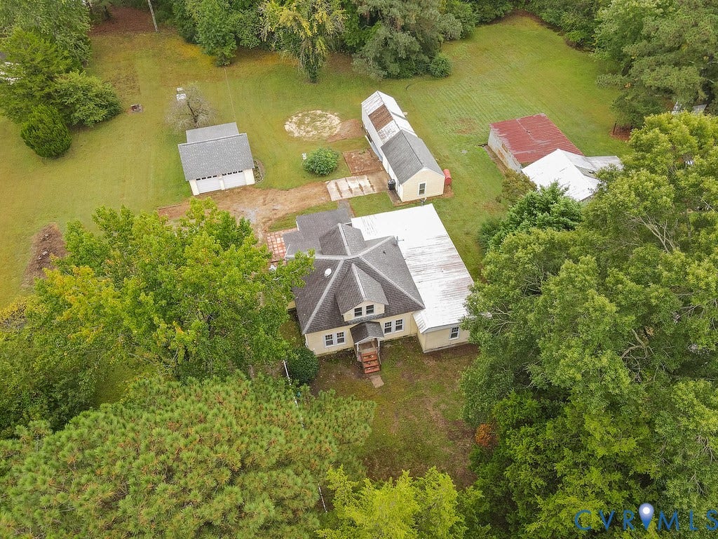Expansive property featuring a central residence, detached outbuilding, and additional structures