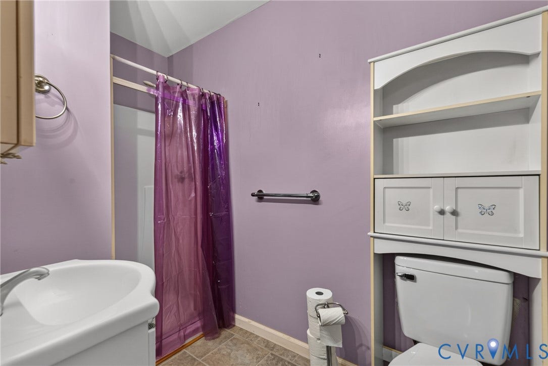 117 Gardners Road, Cross County Area, Mineral, VA 23117 Pedestal sink with chrome faucet, shower enclosure, wall-mounted towel bars, and a toilet with an over-the-toilet storage unit