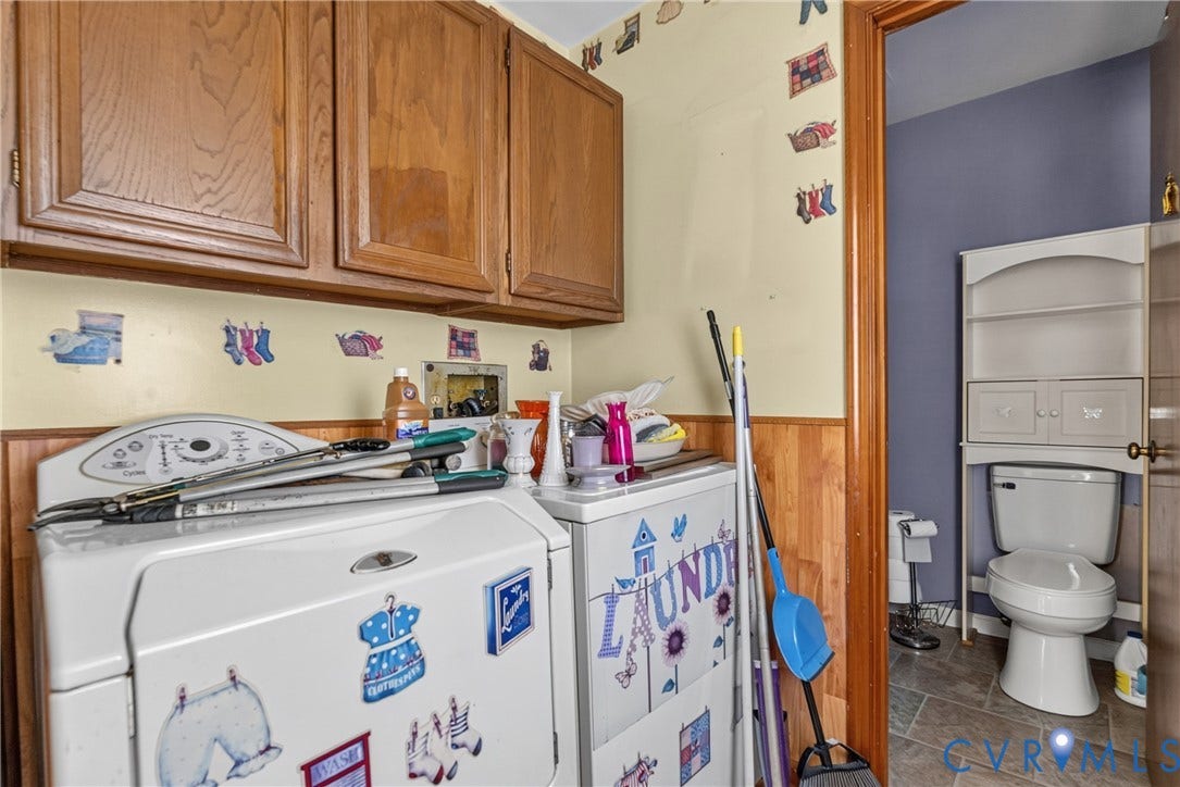 117 Gardners Road, Cross County Area, Mineral, VA 23117 Built-in cabinetry with wood-finish doors, wood paneling, and an adjacent bathroom featuring a toilet with over-the-toilet storage