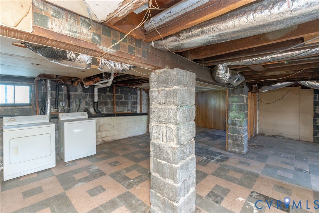 Basement utility space featuring concrete block walls, exposed timber ceiling joists, masonry support pillars, and checkered vinyl flooring