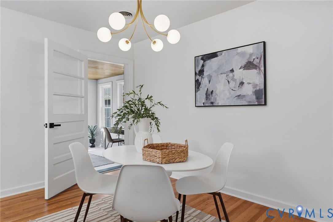 Hardwood flooring, painted white walls, contemporary ceiling light fixture, white interior door with black hardware, and an open doorway