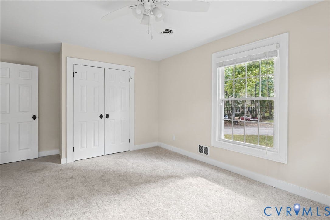 Generous proportions, fresh paint, and new carpeting make this secondary bedroom especially inviting.