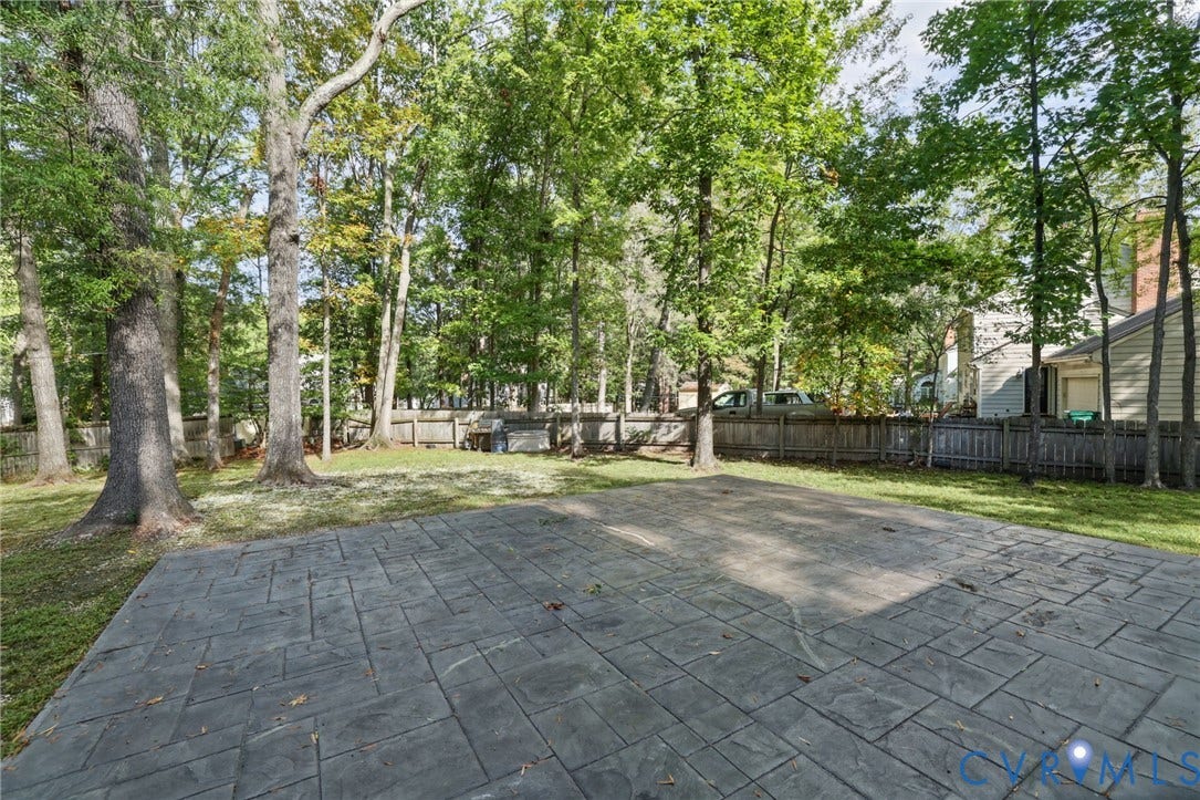 An expansive stamped-concrete patio creates a beautiful setting for outdoor dining and relaxed gatherings.