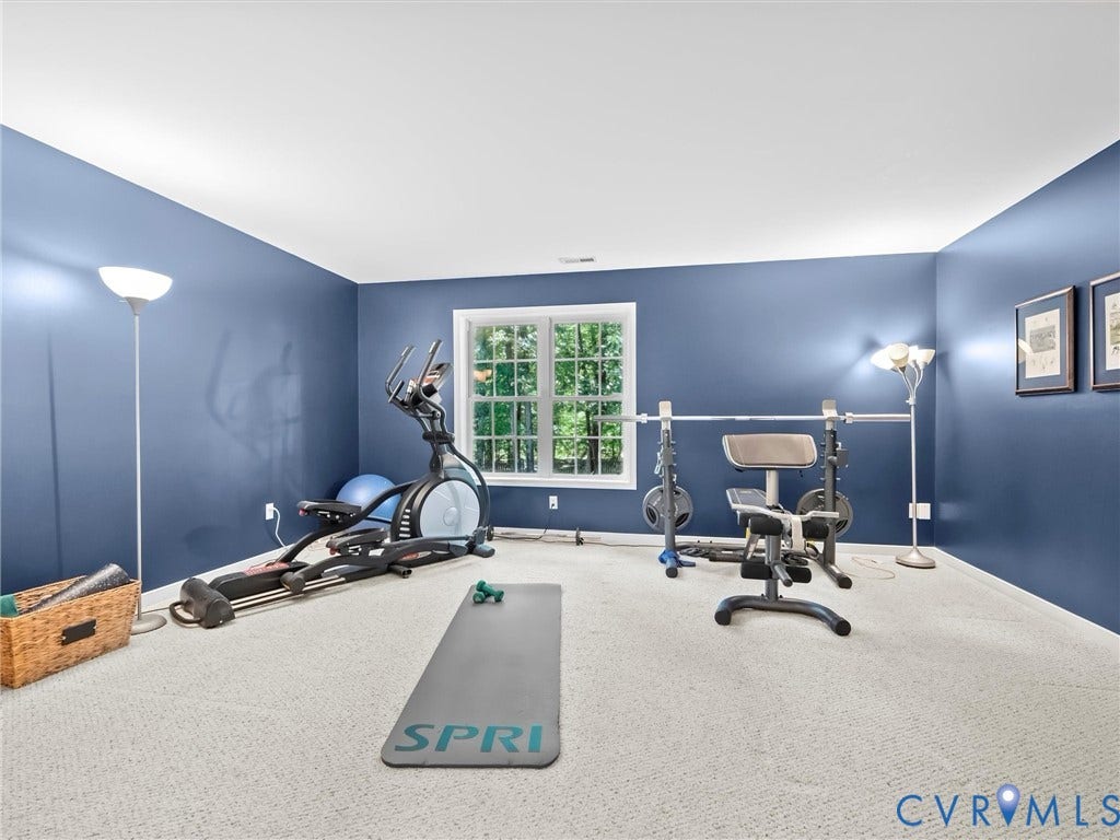 Room featuring a single window, blue painted walls, and light-colored carpet flooring