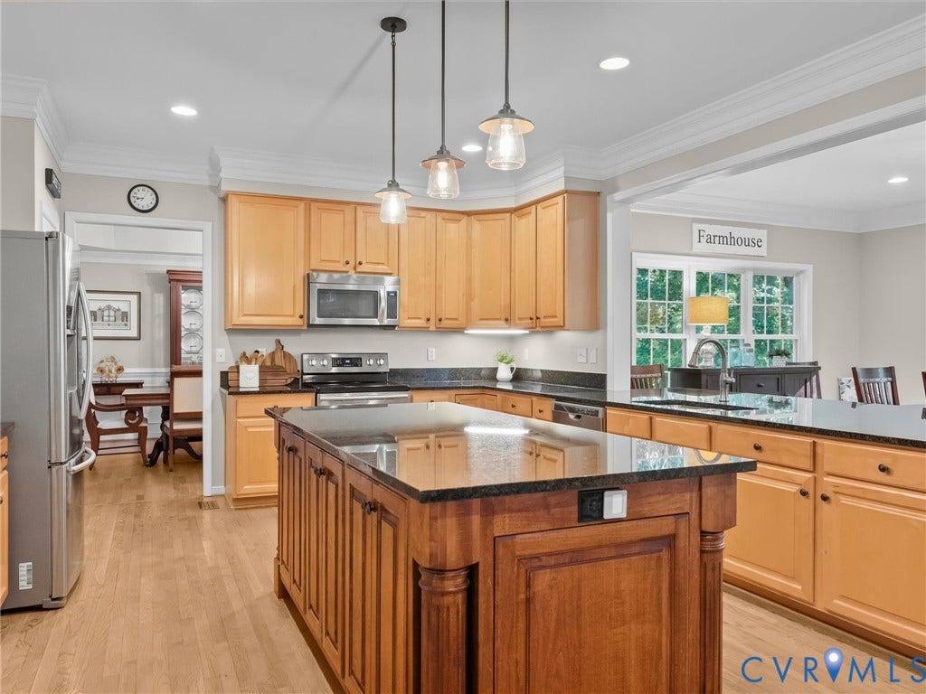 Kitchen featuring wood-finish flooring, recessed lighting, and a center island with a dark countertop